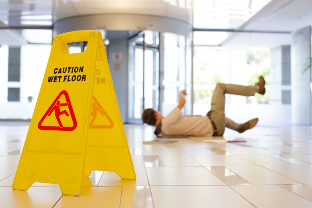 A man on the floor in the lobby of his office after a slip and fall accident.
