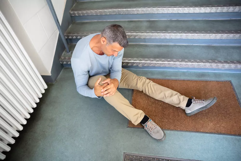 Man sitting on the floor after a slip and fall accident