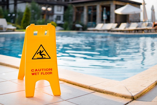 Wet floor sign by luxury hotel swimming pool