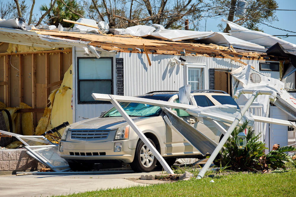Severely damaged by hurricane Ian house and vehicle in Florida mobile home residential area. Consequences of natural disaster.