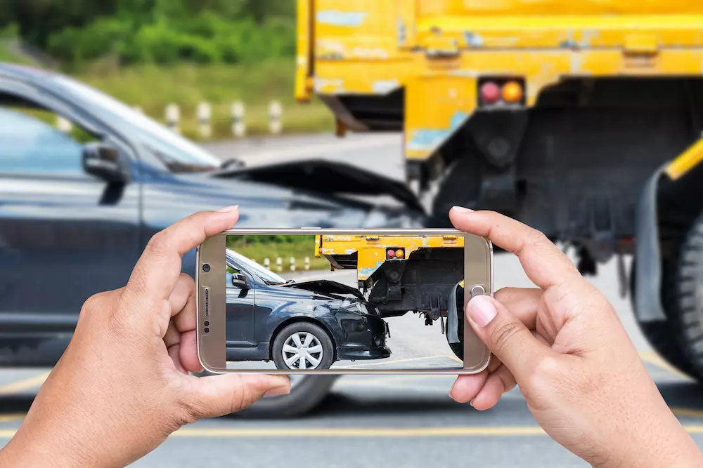 person taking photos of a car accident
