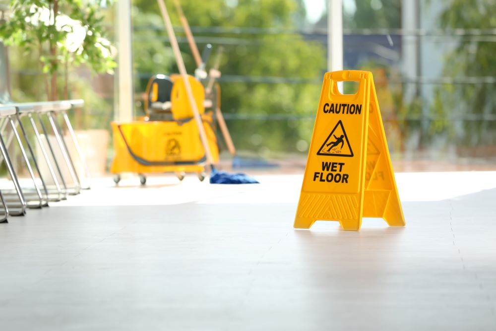 A caution sign in the middle of a lobby to let people know that the area had just been mopped.