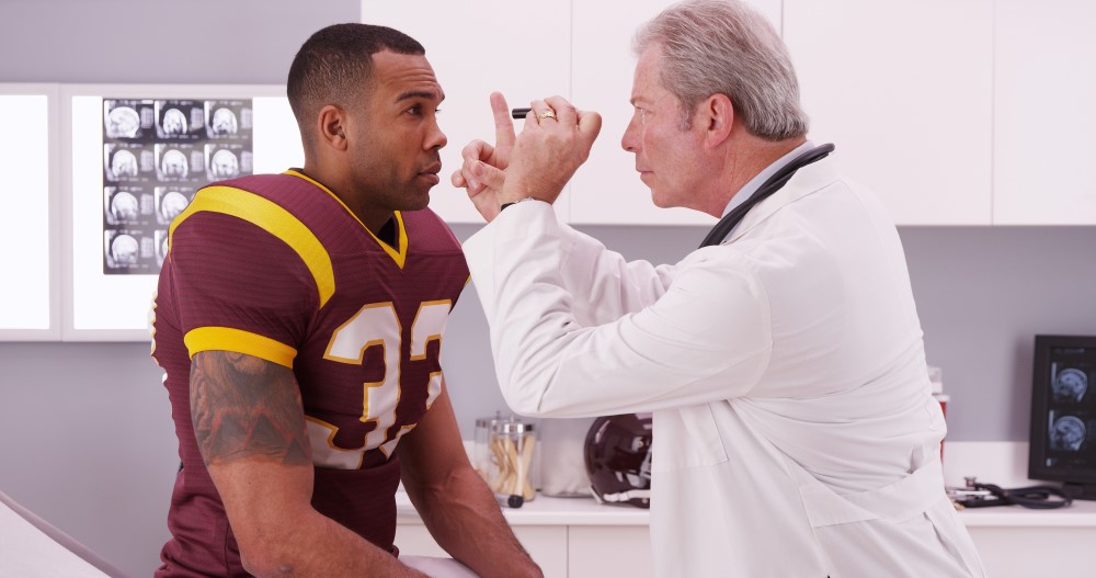 A doctor examining an athlete after a head injury.